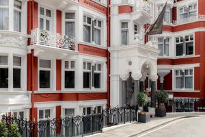 a red and white building with a black fence at Althoff St James's Hotel & Club London in London