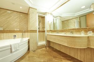 a bathroom with a tub and a large mirror at Hotel Oasi Di Kufra in Sabaudia