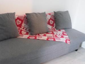um sofá com almofadas e um cobertor em L'Orangerie, studio em Estrasburgo