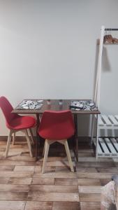 mesa de comedor y 2 sillas rojas en Catumbi Studio 5, en São Paulo
