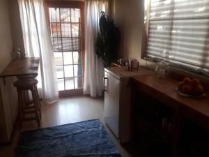 a kitchen with a counter and two windows and a table at Cozy Sarel Cilliers street in Kroonstad