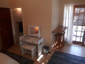 a bedroom with a desk with a tv on it at Cozy Sarel Cilliers street in Kroonstad