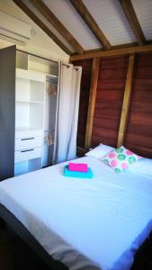 Maison Piscine personnelle vue mer COSY في Le Marin: غرفة نوم بسرير كبير مع شراشف بيضاء