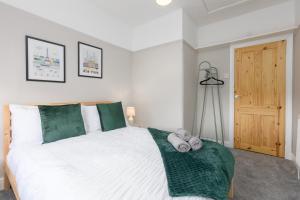 a bedroom with a large white bed with green accents at Charles Alexander Short Stay - Ansdell House in Blackpool
