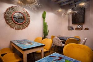 a restaurant with yellow chairs and a table and a cactus at MAMA LOVA Essaouira in Essaouira
