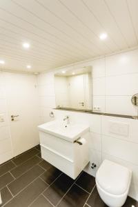 a white bathroom with a toilet and a sink at Strandbrise in Hofe