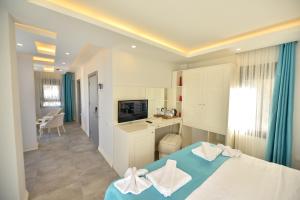 a white bedroom with a blue bed and a desk at The Monastery in Oludeniz