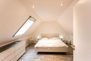 a attic bedroom with a bed and a window at Strandbrise in Hofe