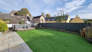 a backyard with a fence and green grass at The Cwtch in Brecon