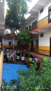 a building with a pool with prayer flags in front of it at The Lumbini Village Lodge in Lumbini