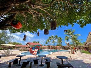a pool with a slide and tables and a playground at Arena Carneiros Hotel by AFT in Tamandaré