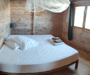una camera da letto con un letto bianco e un asciugamano sopra di Bungalow vert corail a Le Vauclin