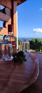 una mesa con dos vasos y una botella de alcohol en Bungalow vert corail en Le Vauclin