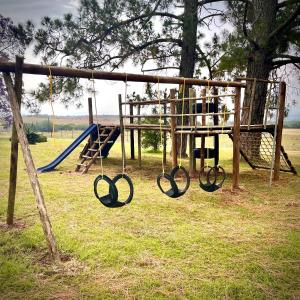 a playground with a slide and a swing at Bellevue Berg Cottage in Bergville
