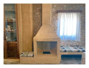 a stone fireplace in a room with a window at KESEMI in Kalavrita