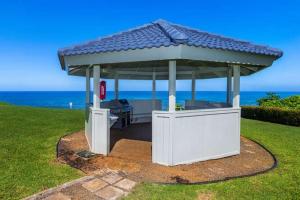 a gazebo with a roof on top of a field at Newly Remodeled Cliffs Resort in Princeville condo in Princeville
