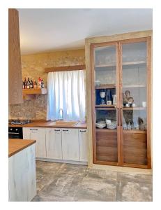 a kitchen with white cabinets and a wooden door at KESEMI in Kalavrita