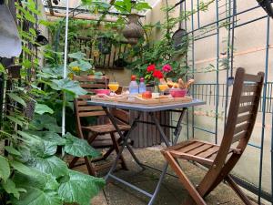 a table and chairs in a garden with plants at Chambre & Lounge Privé Jacuzzi in Marolles-en-Hurepoix
