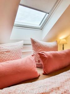 ボルンハイムにあるFriendly Home - "Helles Dachstudio" Köln Bonn Phantasialandのベッドルーム1室(ピンクの枕と天窓付きのベッド2台付)