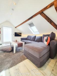 a living room with a couch and a table at Friendly Home - "Helles Dachstudio" Köln Bonn Phantasialand in Bornheim