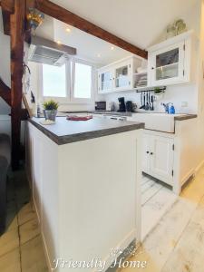 a kitchen with white cabinets and a counter top at Friendly Home - "Helles Dachstudio" Köln Bonn Phantasialand in Bornheim