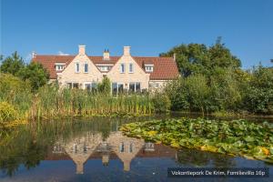 a house in the middle of a pond with lilies at Vakantiepark De Krim Texel in De Cocksdorp