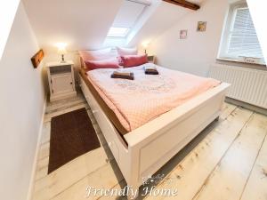 a bedroom with a large bed with pink pillows at Friendly Home - "Helles Dachstudio" Köln Bonn Phantasialand in Bornheim