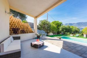 ein Haus mit einem Pool und einer Terrasse in der Unterkunft BELLET HILLS VI4193 by Riviera Holiday Homes in Nizza