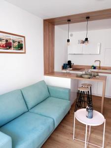 a living room with a blue couch and a kitchen at Charmant Studio Refait à neuf Centre de Tours in Tours