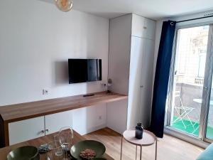 a living room with a tv on a wall at Charmant Studio Refait à neuf Centre de Tours in Tours