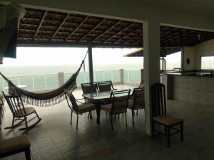 里约热内卢Hostel Vista do Mar的一间带吊床和桌椅的用餐室