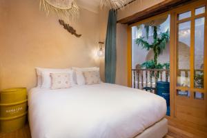 um quarto com uma cama branca e uma janela em MAMA LOVA Essaouira em Essaouira