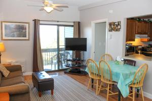 a living room with a table and chairs and a television at Tree Top Getaway in Laconia