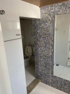 a bathroom with a toilet and a white door at Pousada Pinheiro in Campos dos Goytacazes