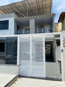 uma porta de garagem branca em frente a uma casa em Pousada Pinheiro em Campos dos Goytacazes