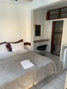 een slaapkamer met een groot bed en een stoel. bij Pousada Pinheiro in Campos dos Goytacazes