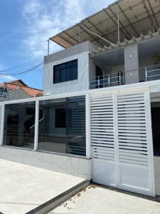 una casa blanca con una puerta de garaje blanca en Pousada Pinheiro, en Campos dos Goytacazes