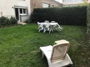 a group of white tables and chairs on a lawn at T2 Rdc, jardin, calme, parking, idéalement placé in Issoire