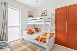 a bedroom with two bunk beds and a ladder at Coast at Beachdown in Bigbury