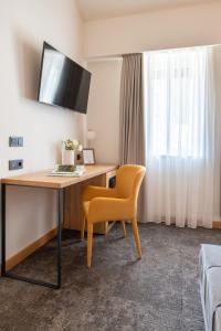 a hotel room with a desk and a yellow chair at Botrytis Borhotel in Mád