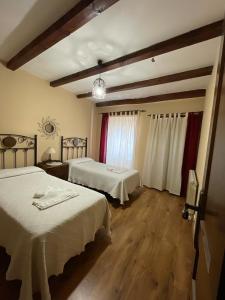 ein Hotelzimmer mit 2 Betten und einem Fenster in der Unterkunft Casa Rural Calderon de Medina I y II in Siete Iglesias de Trabancos