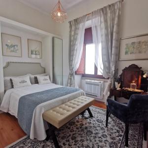 een slaapkamer met een bed, een stoel en een raam bij Chalet Vitorino in Sintra