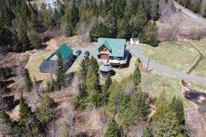 an aerial view of a house with a blue roof at Chalet en bois rond in Saint-Herménégilde