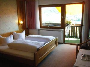 ein Hotelzimmer mit einem Bett und einem großen Fenster in der Unterkunft Hotel Schauinsland in Bad Peterstal-Griesbach