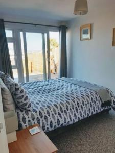 a bedroom with a bed and a large window at The Getaway - Modern 2 Bedroom Brixham Bungalow with sea peeps in Brixham