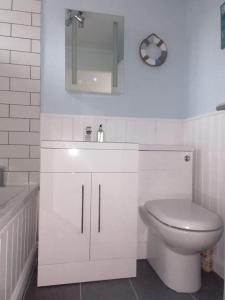 ein Badezimmer mit einem WC, einem Waschbecken und einer Badewanne in der Unterkunft The Getaway - Modern 2 Bedroom Brixham Bungalow with sea peeps in Brixham