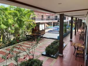 un patio esterno con tavoli, sedie e piscina di Confetti Garden Resort a Vang Vieng