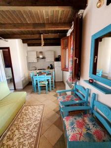 un soggiorno con sedie blu e una cucina di Camere Sinis Isprocilis a Palmas Arborea