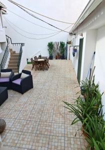 un patio con mesa, sillas y escaleras en Casa Faroleiro en Nazaré