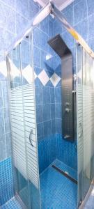 a shower in a bathroom with blue tiles at COZY LUXURY Appartment Near The City in Igoumenitsa